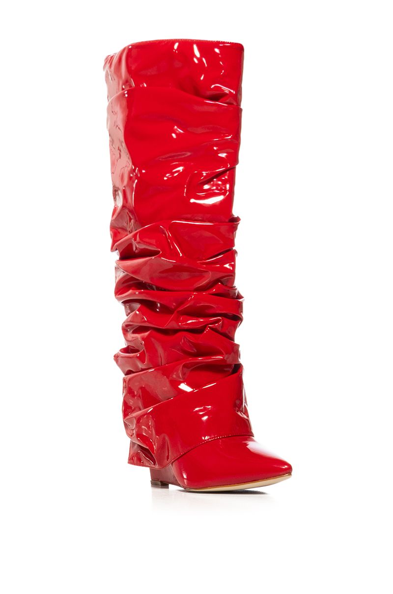angled view of shiny red patent faux leather wedge boots with a ruched detail and fold over silhouette