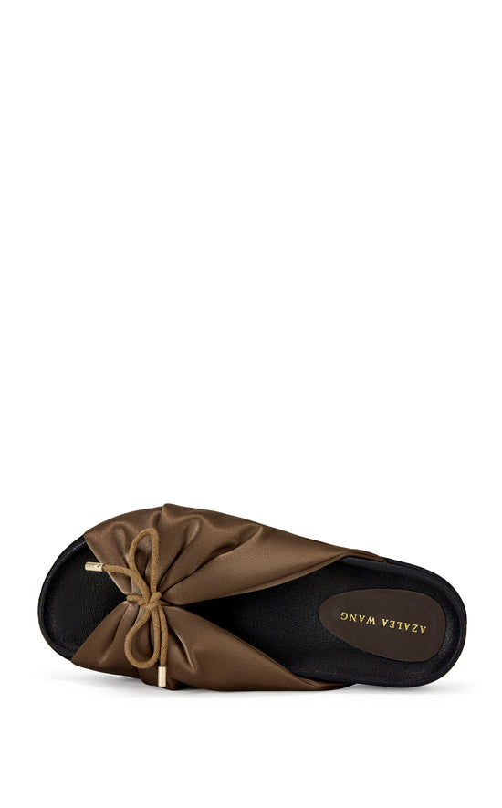 brown satin slip on sandals with a black sole and a bow accent on the upper