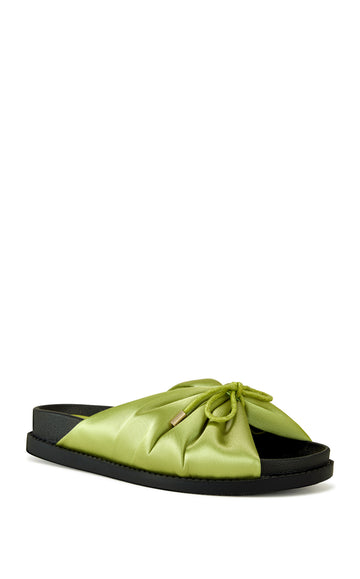 green satin slip on sandals with a black sole and a bow accent on the upper