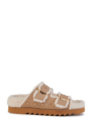 beige slip on sherpa lined cozy sandals with gold hardware accents and a ridged sole