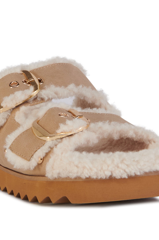 beige slip on sherpa lined cozy sandals with gold hardware accents and a ridged sole