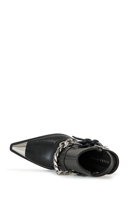 black faux leather statement western boots with a metal toe, black block heel, and and ankle cutout secured with a belted ankle strap closure