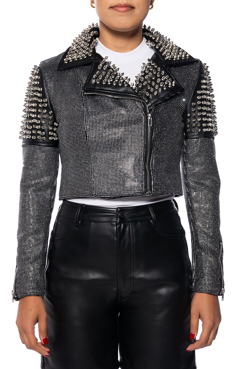 front view of cropped black faux leather jacket with studded shoulders and collars and shiny crystal embellishments