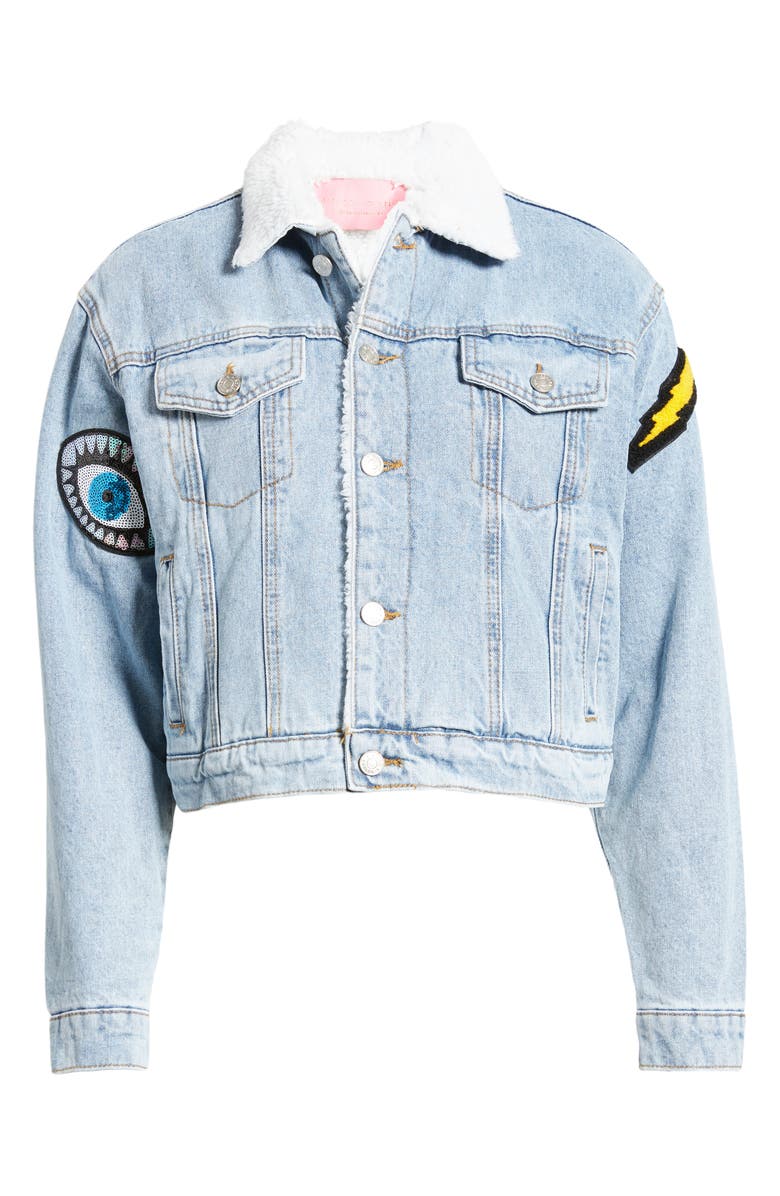 light wash denim jacket with button up closure and decorative patches on the sleeve and back of the jacket