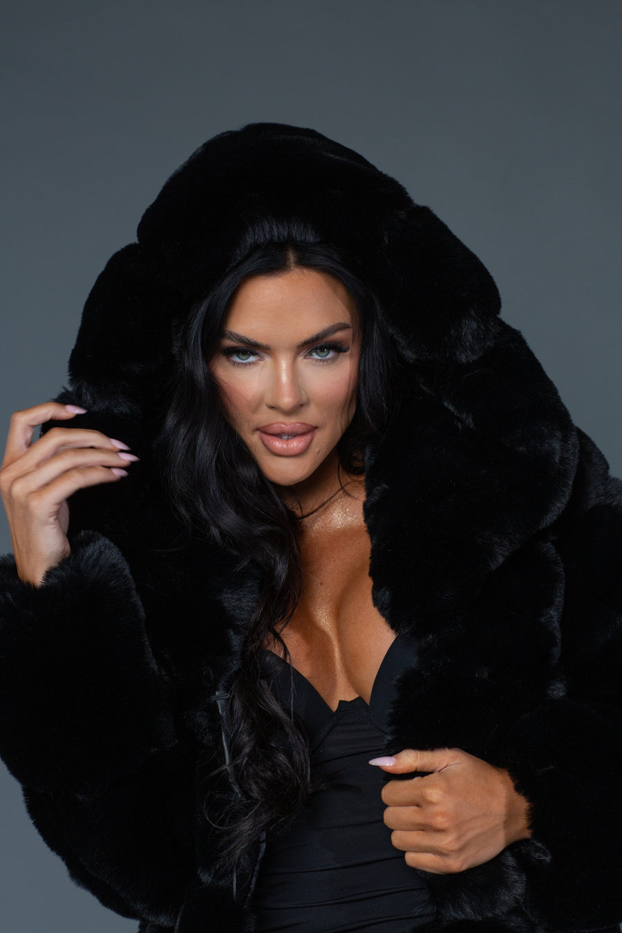 close up of Model posing while wearing black faux fur trench coat