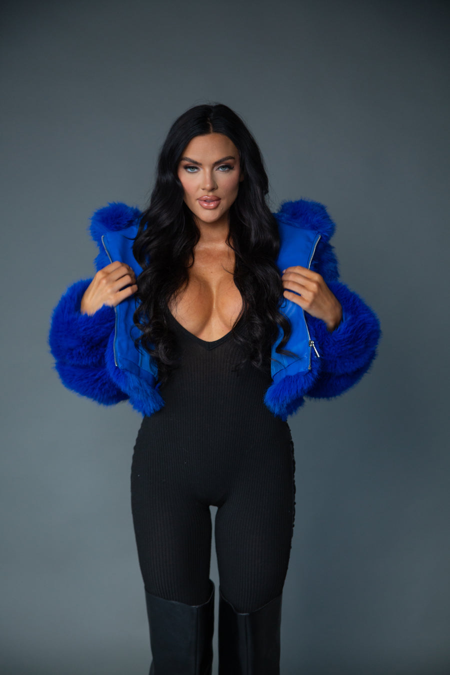 close up of Model posing while wearing cobalt blue faux fur cropped statement jacket for fall