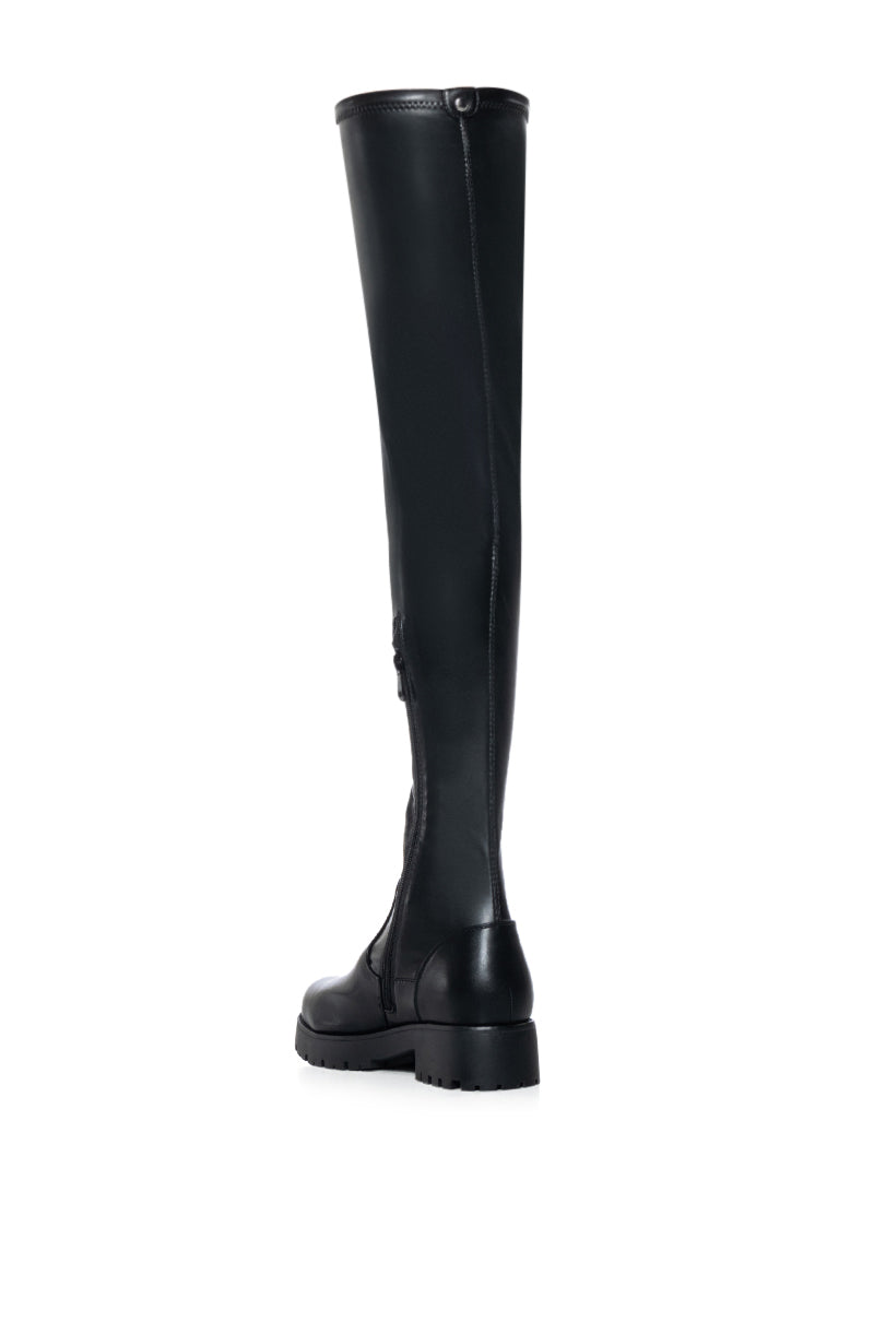 back view of black faux leather over the knee stretchy flat boot made with 4 way stretch material