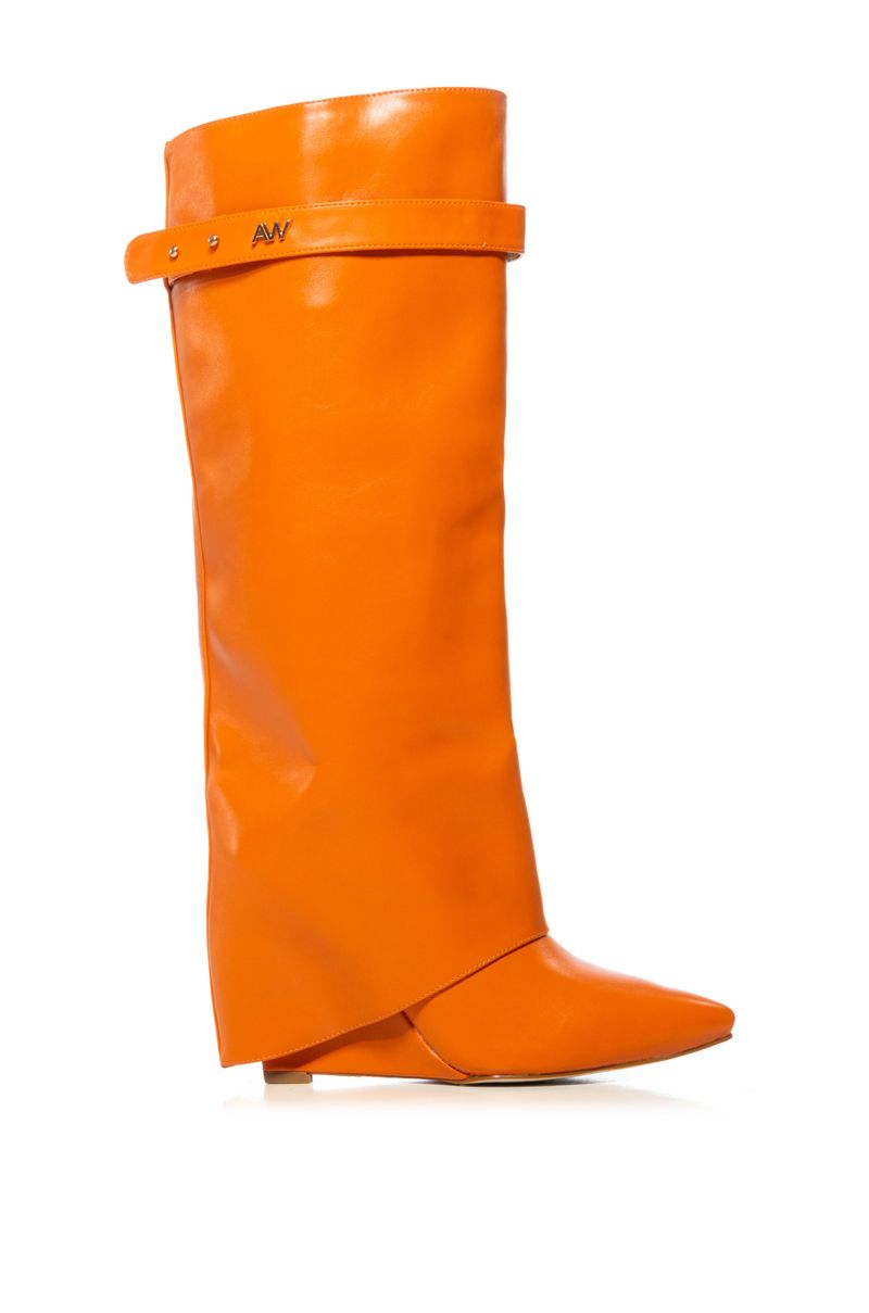 side view of fashion forward orange faux leather wedge fold over boots with a pointed toe
