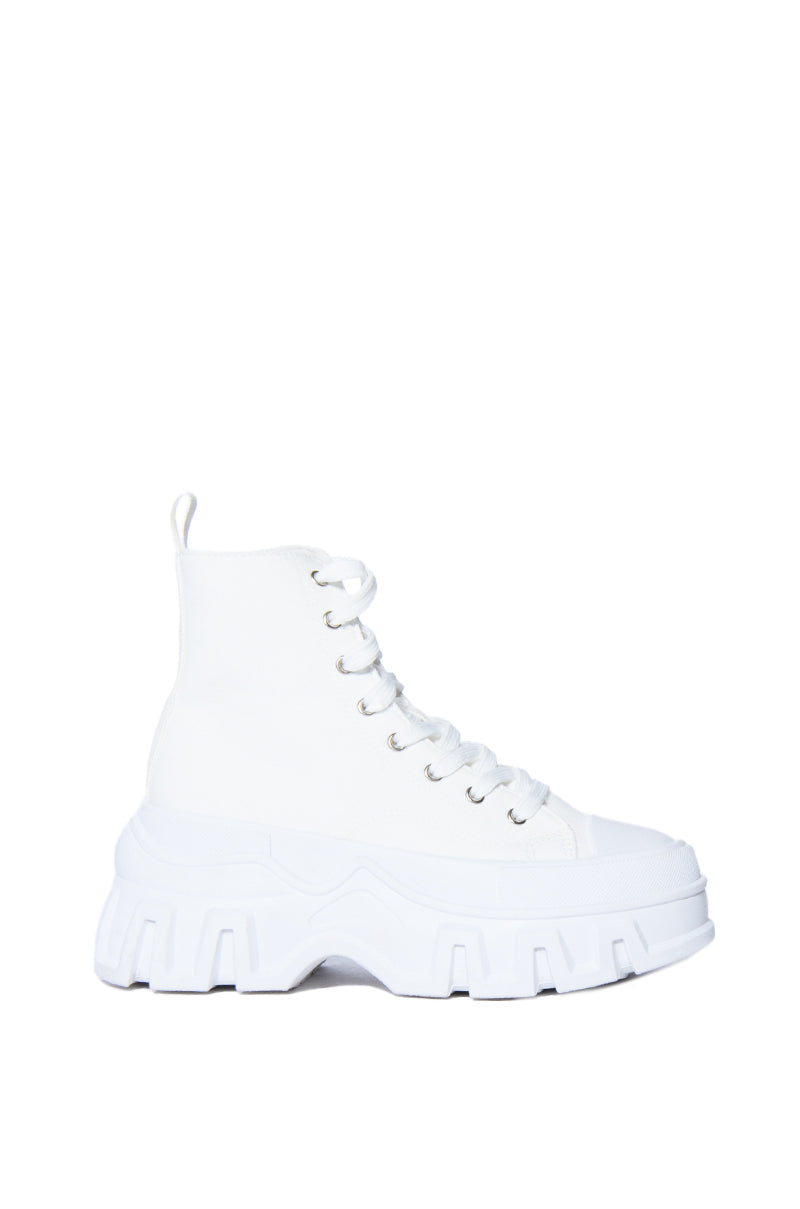 white platform lace up sneakers with a chunky white sole and laces