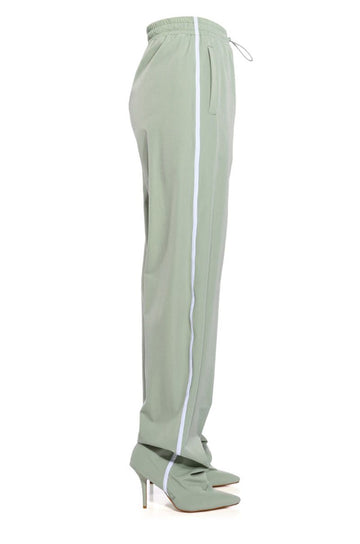 sage green pointed toe stiletto boots attached to drawstring track pants with white stripe