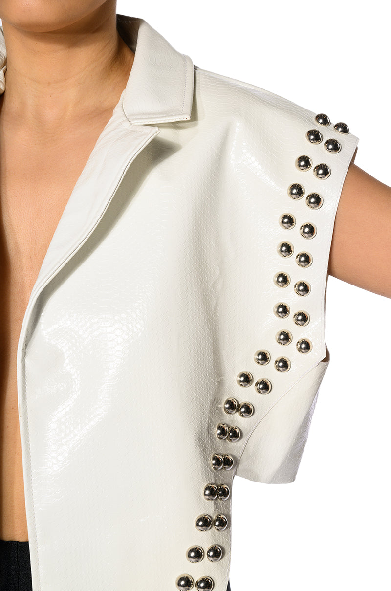 detail shot of white faux leather flared collar vest with studs along the sides